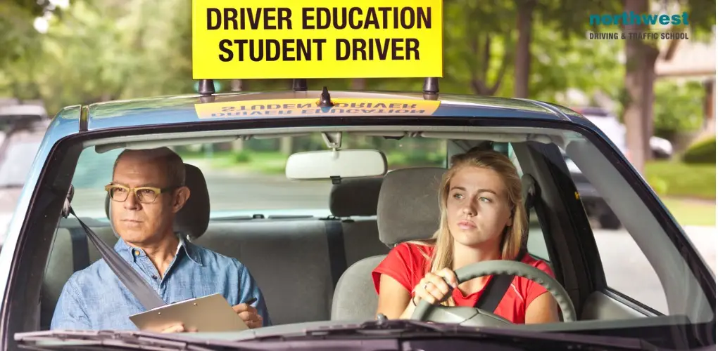 Student driver driving car with instructor