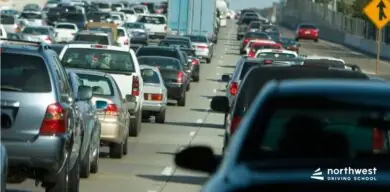 Heavy traffic jam on a multi-lane highway with numerous cars and trucks.