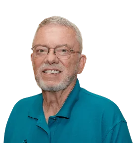 Smiling older man with glasses and a beard, wearing a teal polo shirt against a plain background.