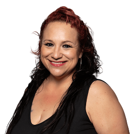 Smiling woman with long, dark hair and red highlights, wearing a black tank top against a plain background.