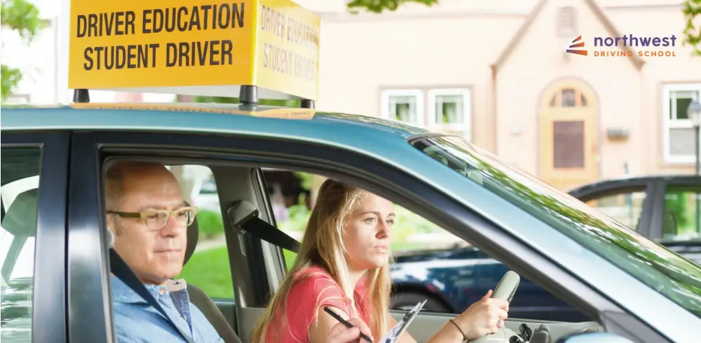 A student driver practices with an instructor in a car marked for driver education.