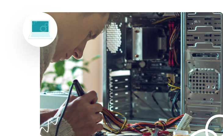 A person is focused on assembling or repairing a computer, surrounded by wires and components.